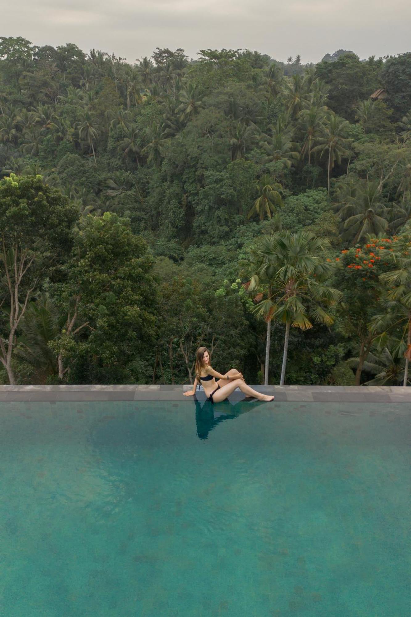 Goya Boutique Resort Ubud Exterior foto A woman sitting on the edge of a swimming pool